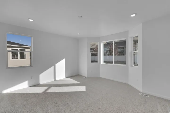Empty room with carpet and recessed lighting
