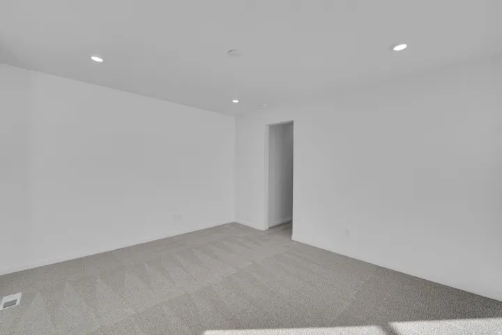 Carpeted spare room featuring recessed lighting
