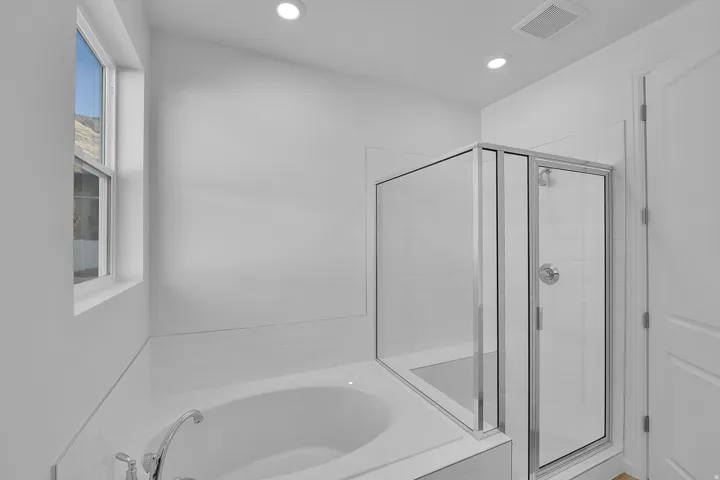 Full bathroom featuring a bath, a stall shower, and recessed lighting