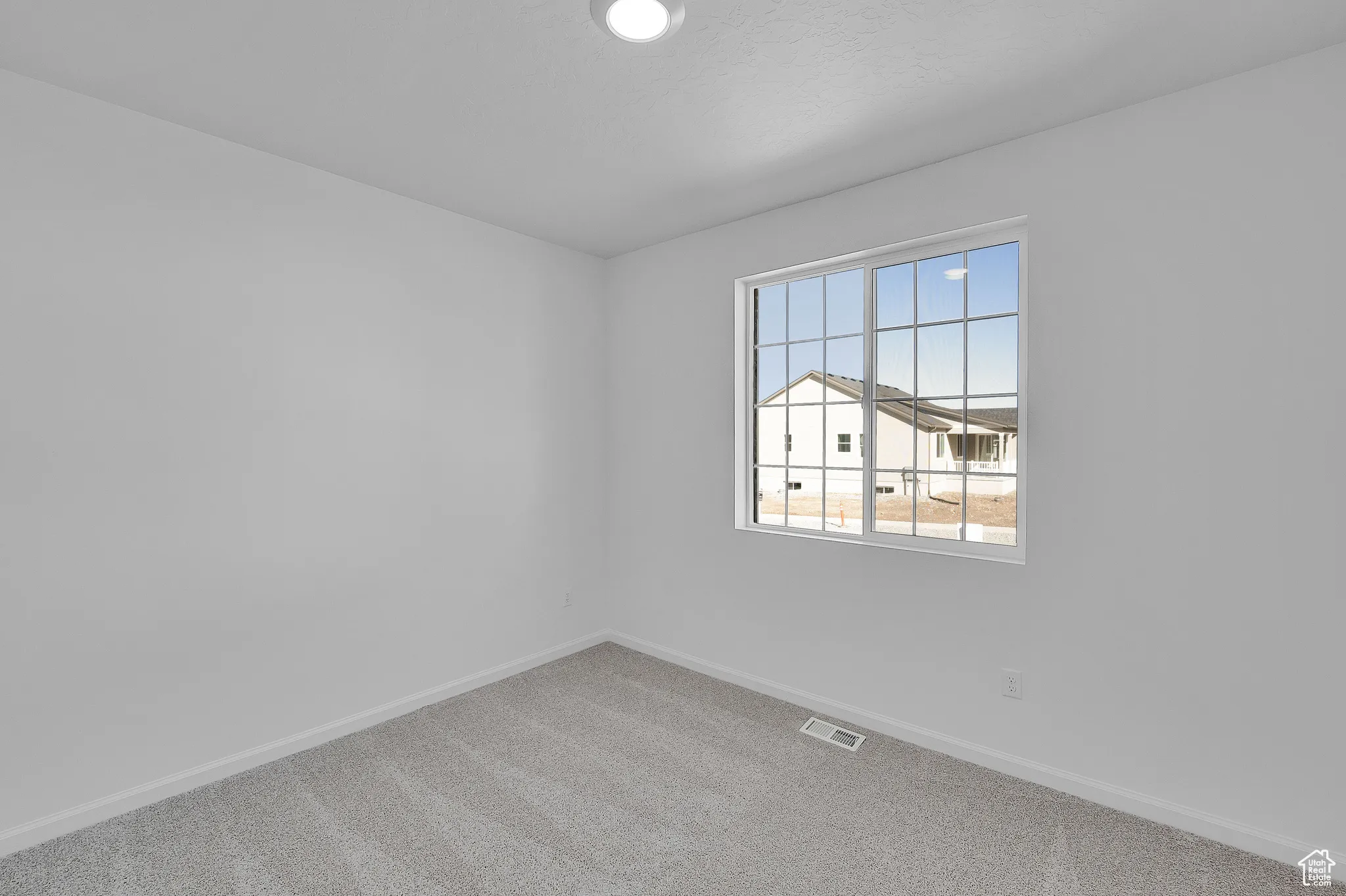 Empty room featuring carpet flooring and baseboards