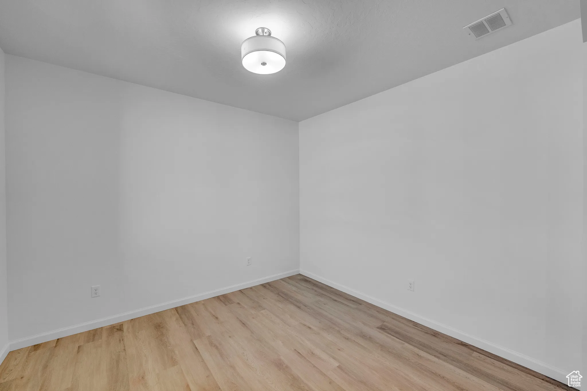 Unfurnished room with light wood-style floors and baseboards