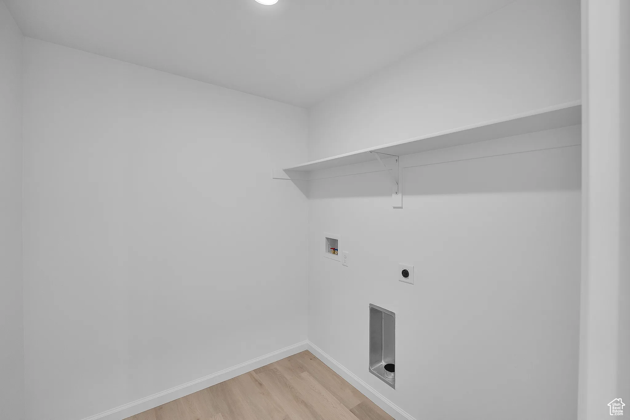 Laundry room featuring light wood-style flooring, hookup for a washing machine, and hookup for an electric dryer