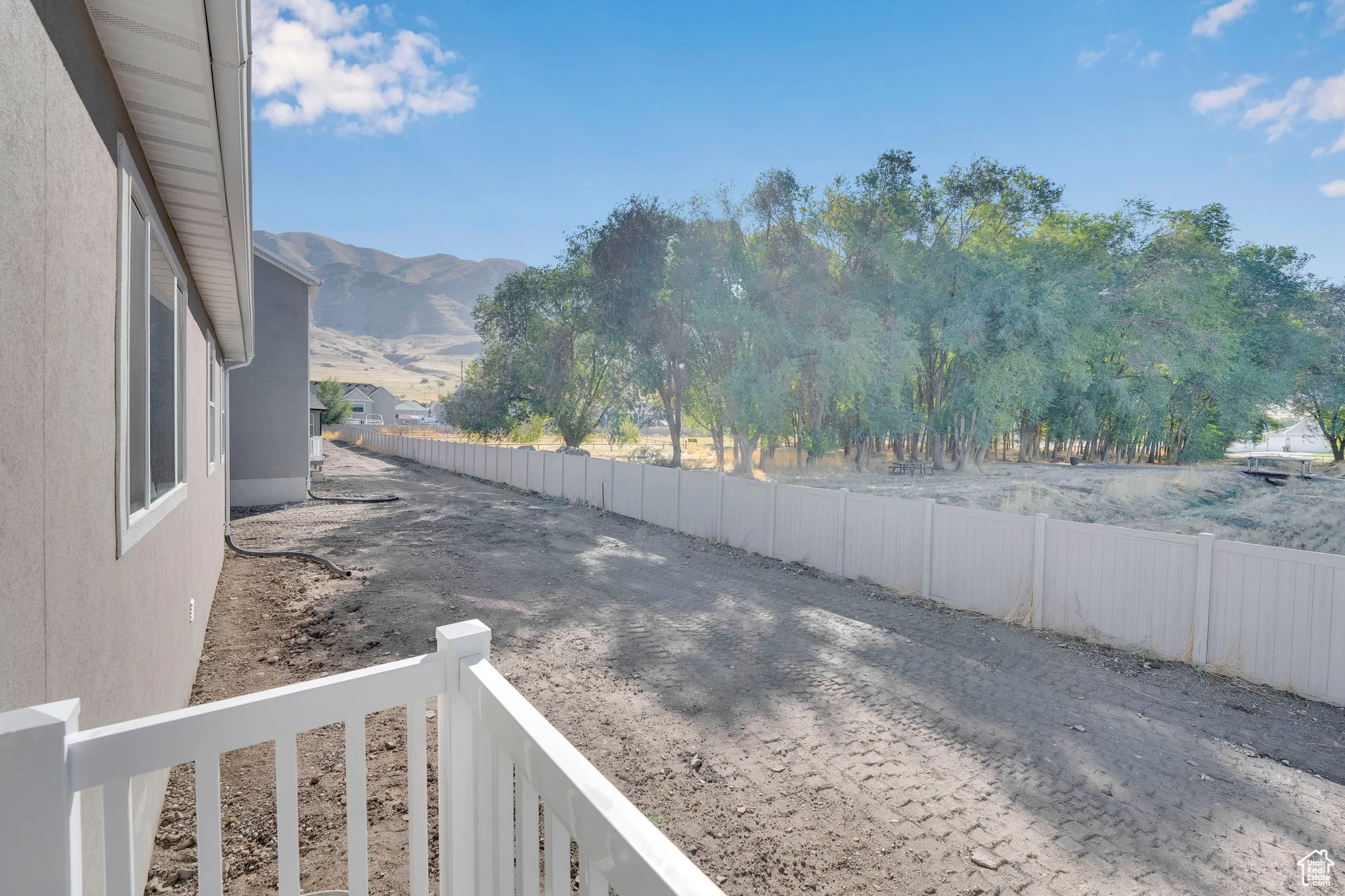 Fenced backyard with a mountain view and a balcony