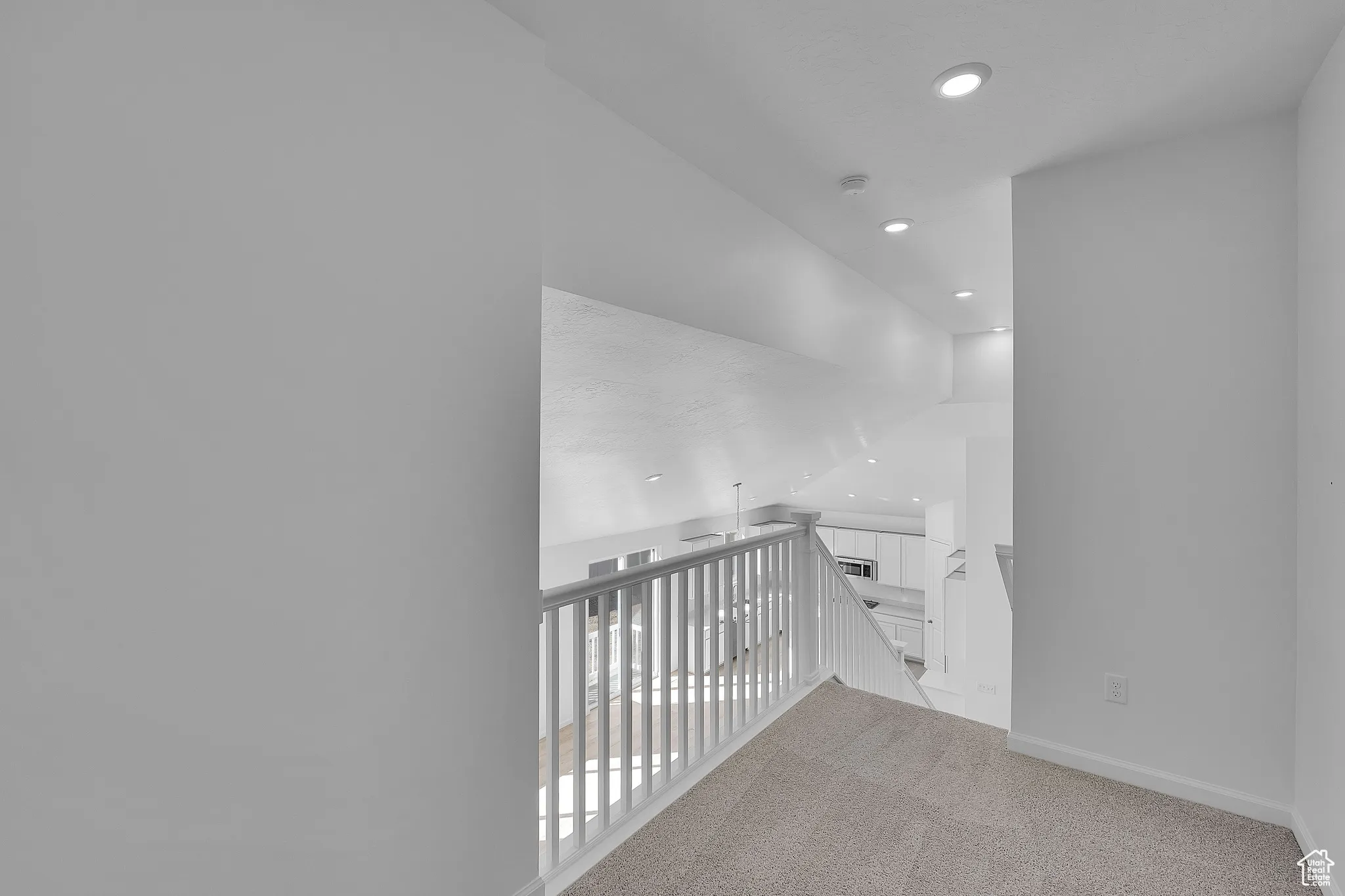 Corridor featuring light colored carpet, an upstairs landing, and recessed lighting