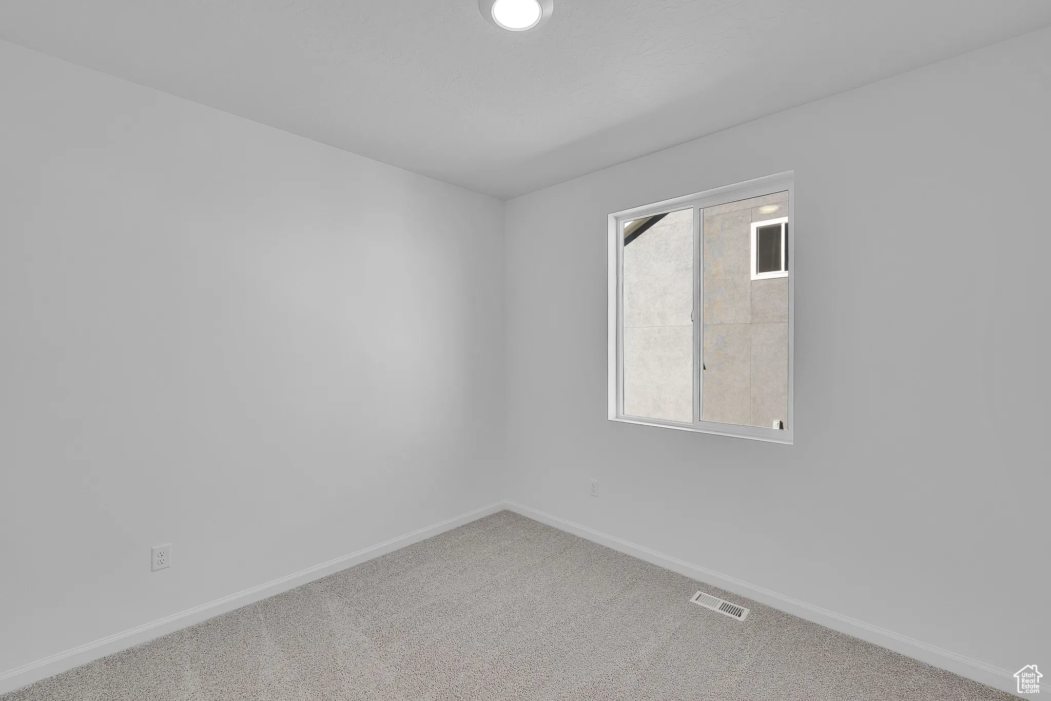 Carpeted spare room with baseboards