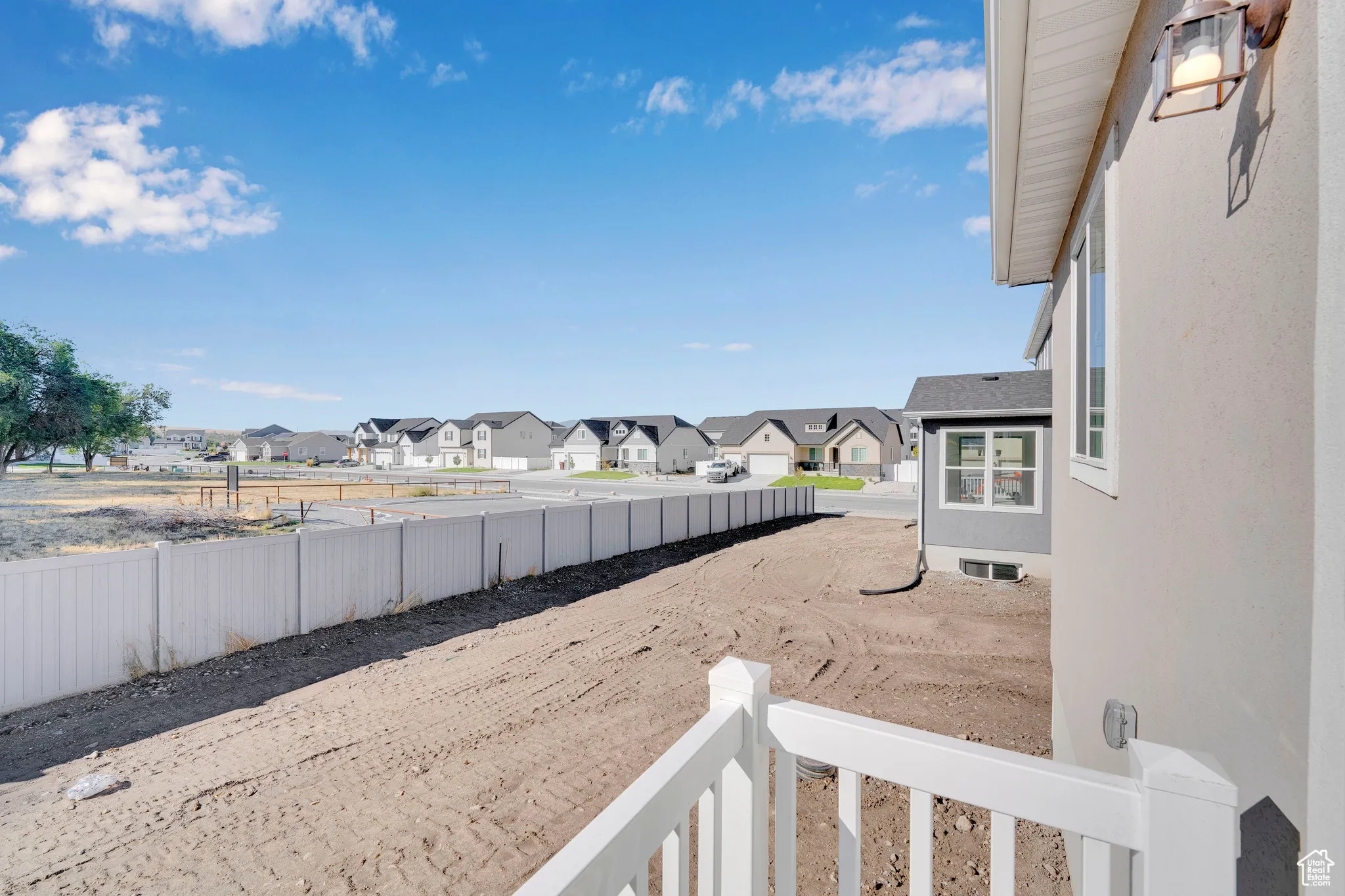 Fenced backyard featuring a residential view and a balcony