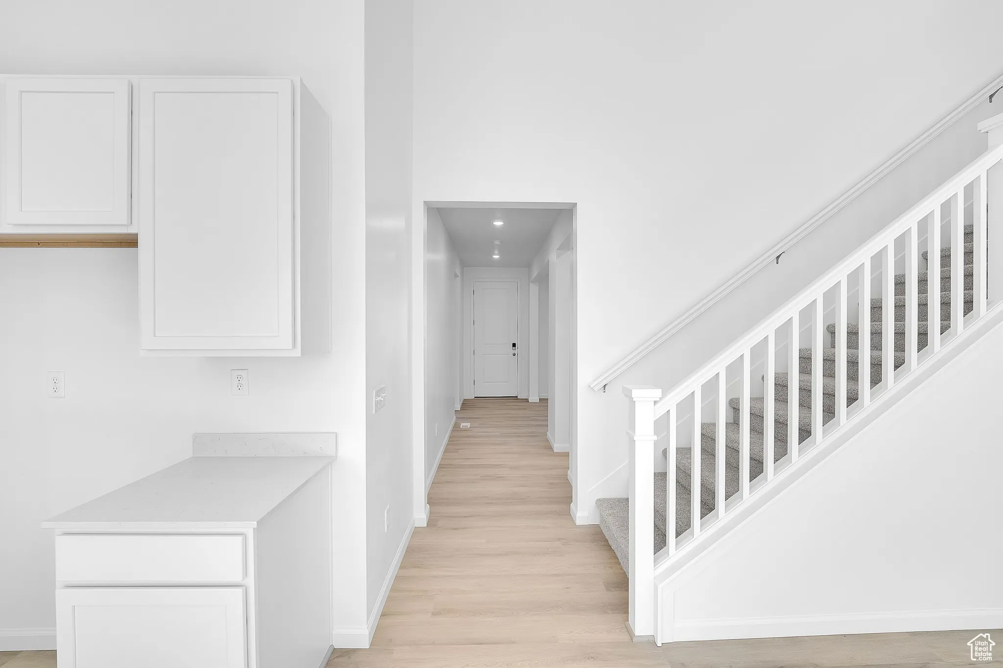 Corridor featuring light wood-style flooring and stairs