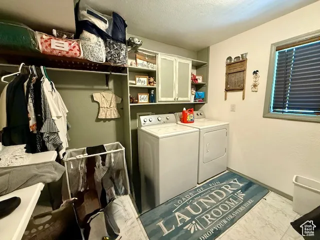 Laundry area with washer and dryer, cabinet space, and marble finish floors