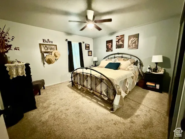 Carpeted bedroom featuring ceiling fan and baseboards