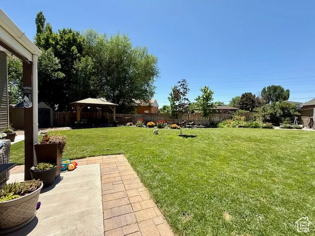 View of yard featuring a storage shed, a gazebo, and a patio
