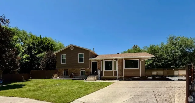 Split level home featuring brick siding and concrete driveway