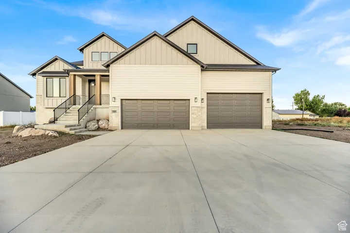 Modern inspired farmhouse featuring board and batten siding, concrete driveway, and a garage