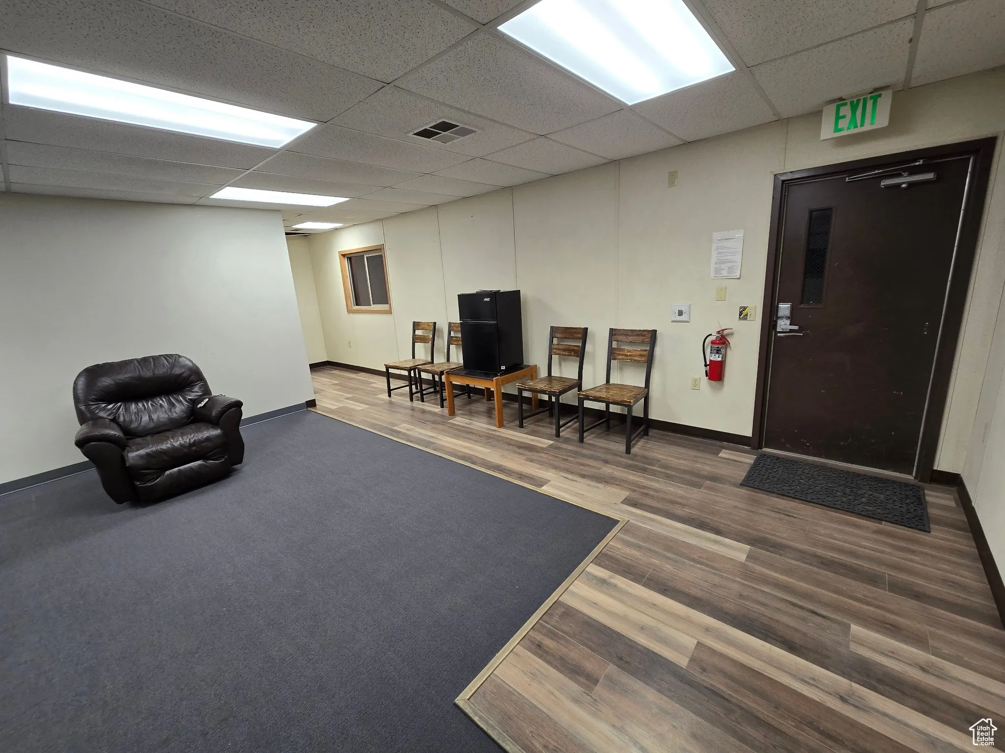 Living area with a drop ceiling and wood finished floors