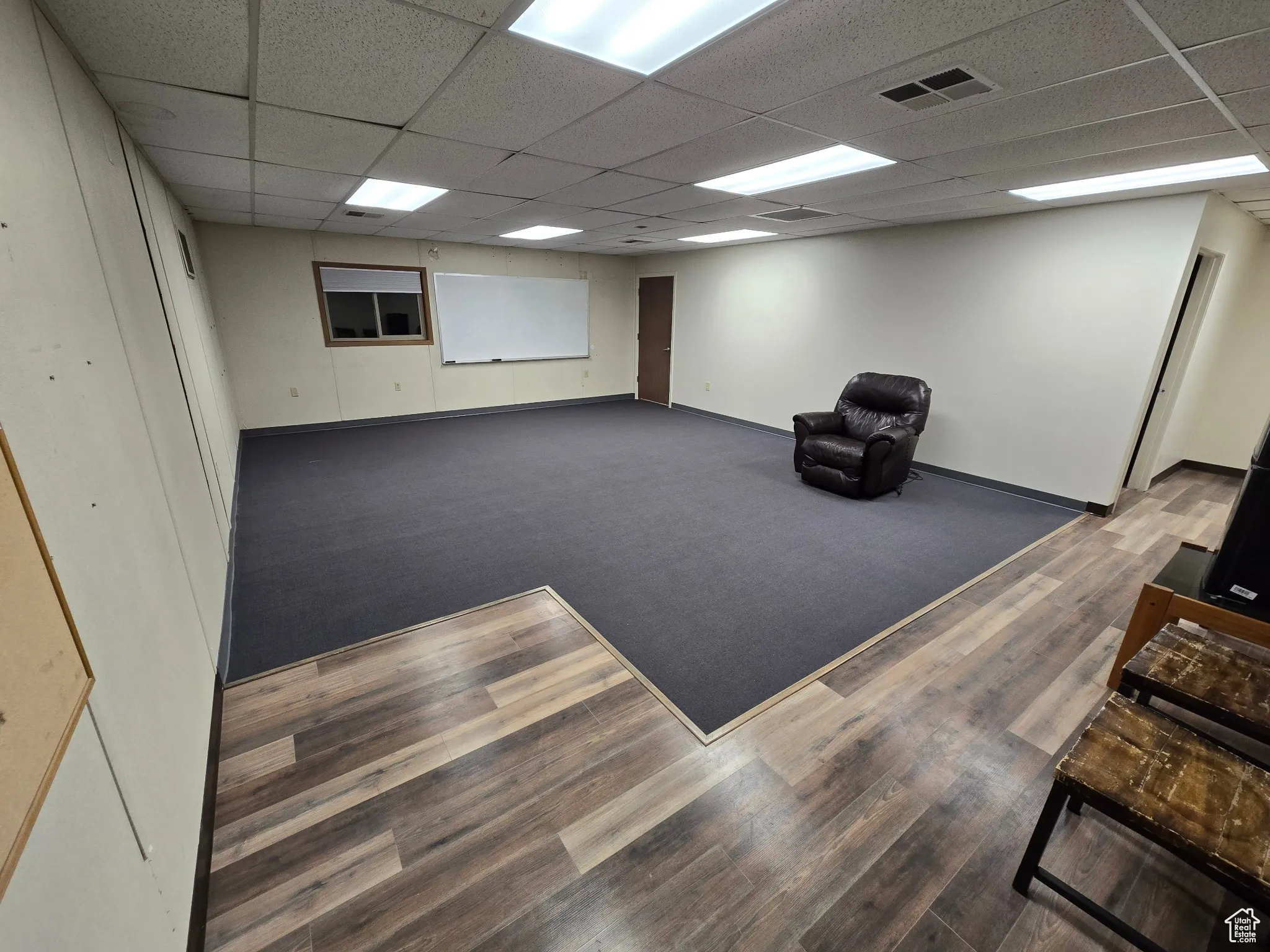 Unfurnished room with a paneled ceiling and wood finished floors