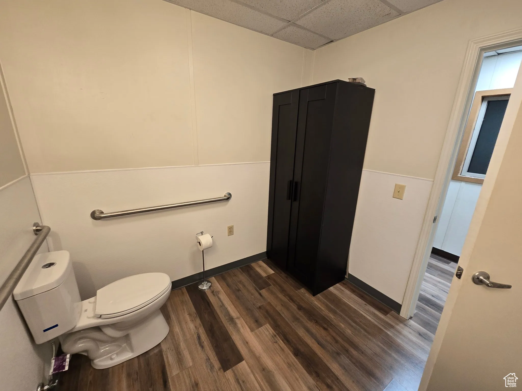 Bathroom with wood finished floors and a drop ceiling