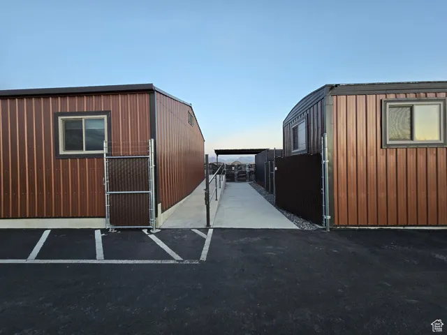 View of outdoor structure with uncovered parking