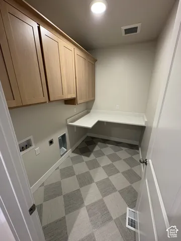 Built-in wood-finish cabinetry, L-shaped countertop, recessed ceiling lighting, checkered flooring, and a white interior door