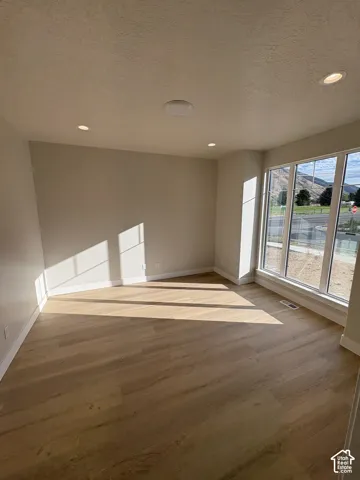 Expansive windows, wood-finish flooring, recessed lighting, and a neutral color palette