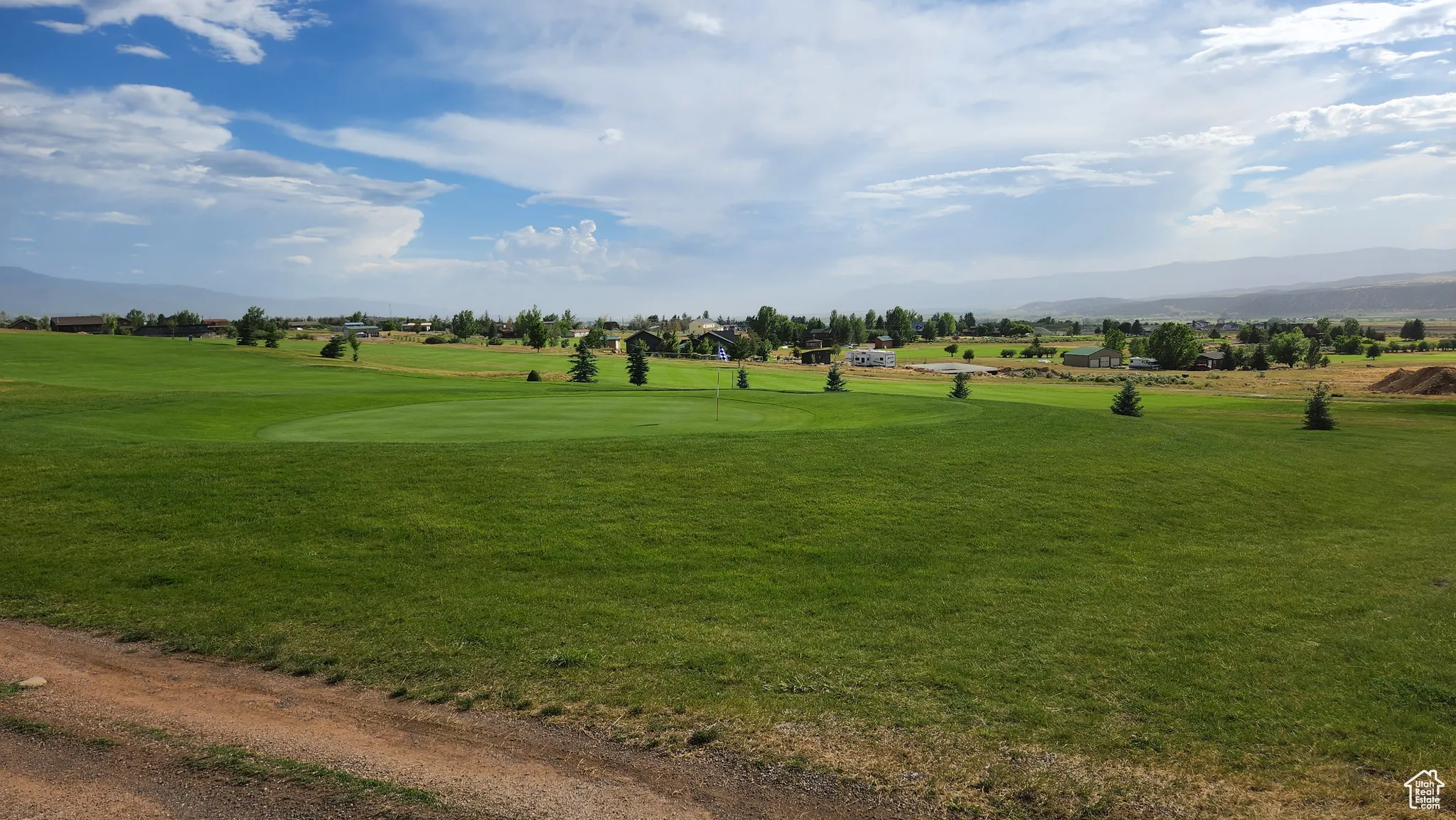 View of community featuring a mountain view, a yard, and view of golf course