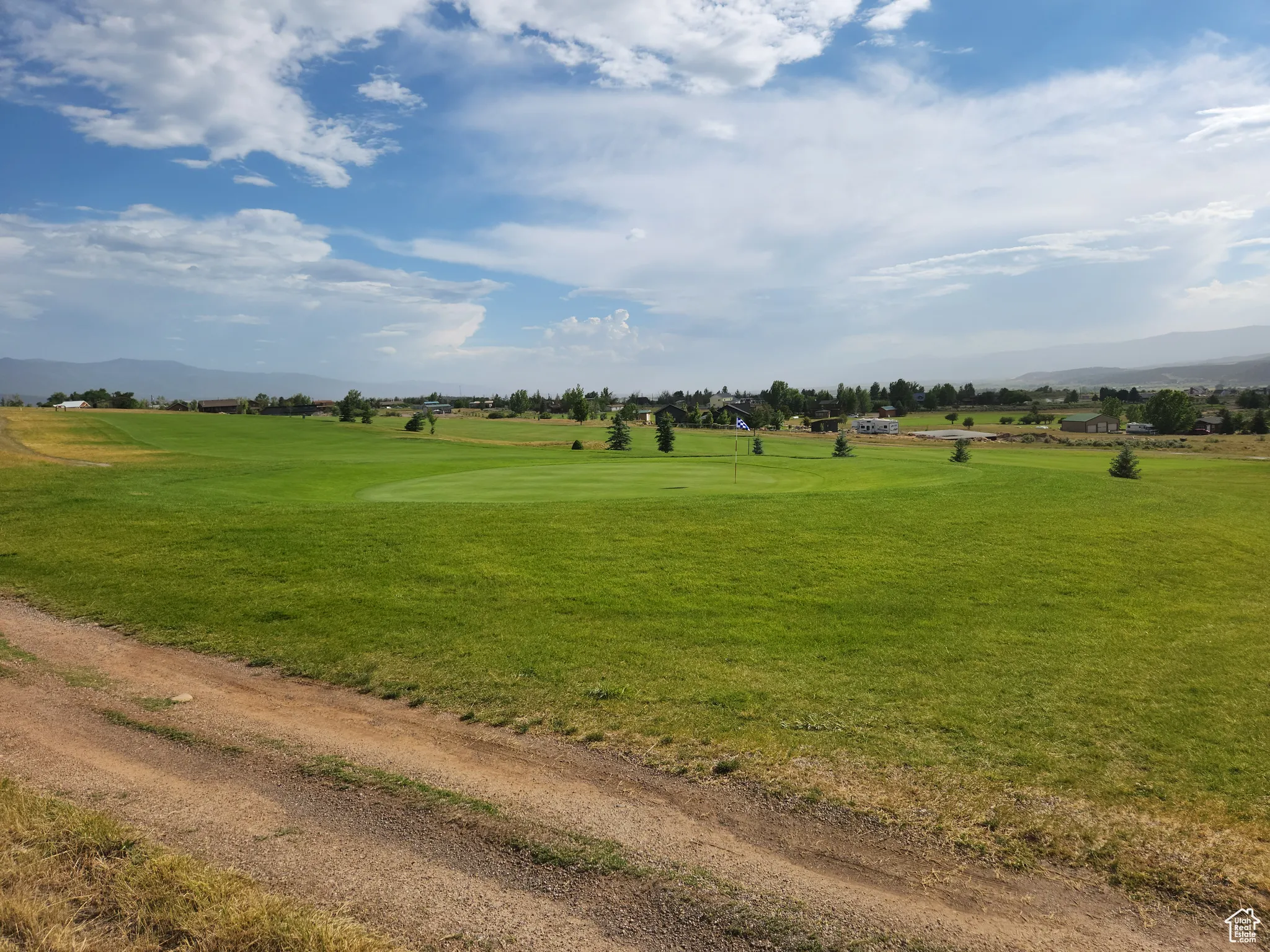 View of property's community featuring a mountain view, a yard, and view of golf course