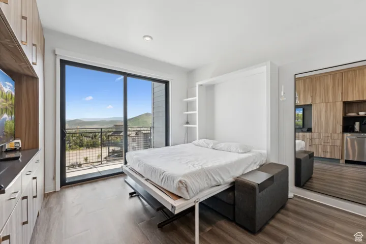 Bedroom featuring access to outside, dark wood-type flooring, recessed lighting, and a mountain view
