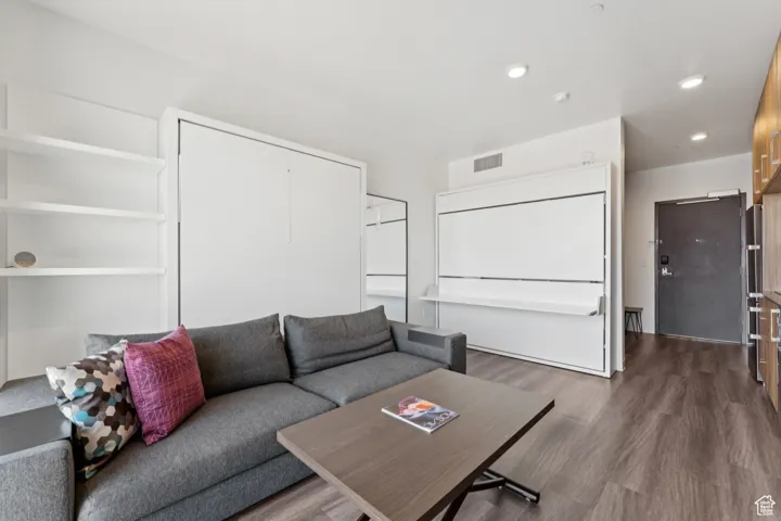 Living area with dark wood-type flooring and recessed lighting