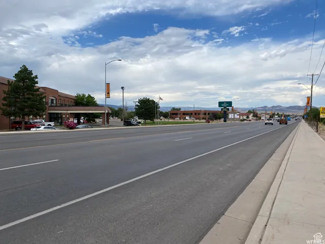 View of asphalt street with sidewalks, street lights, curbs, and a mountain view