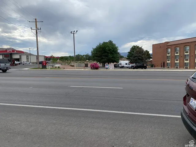 View of asphalt road featuring sidewalks and curbs