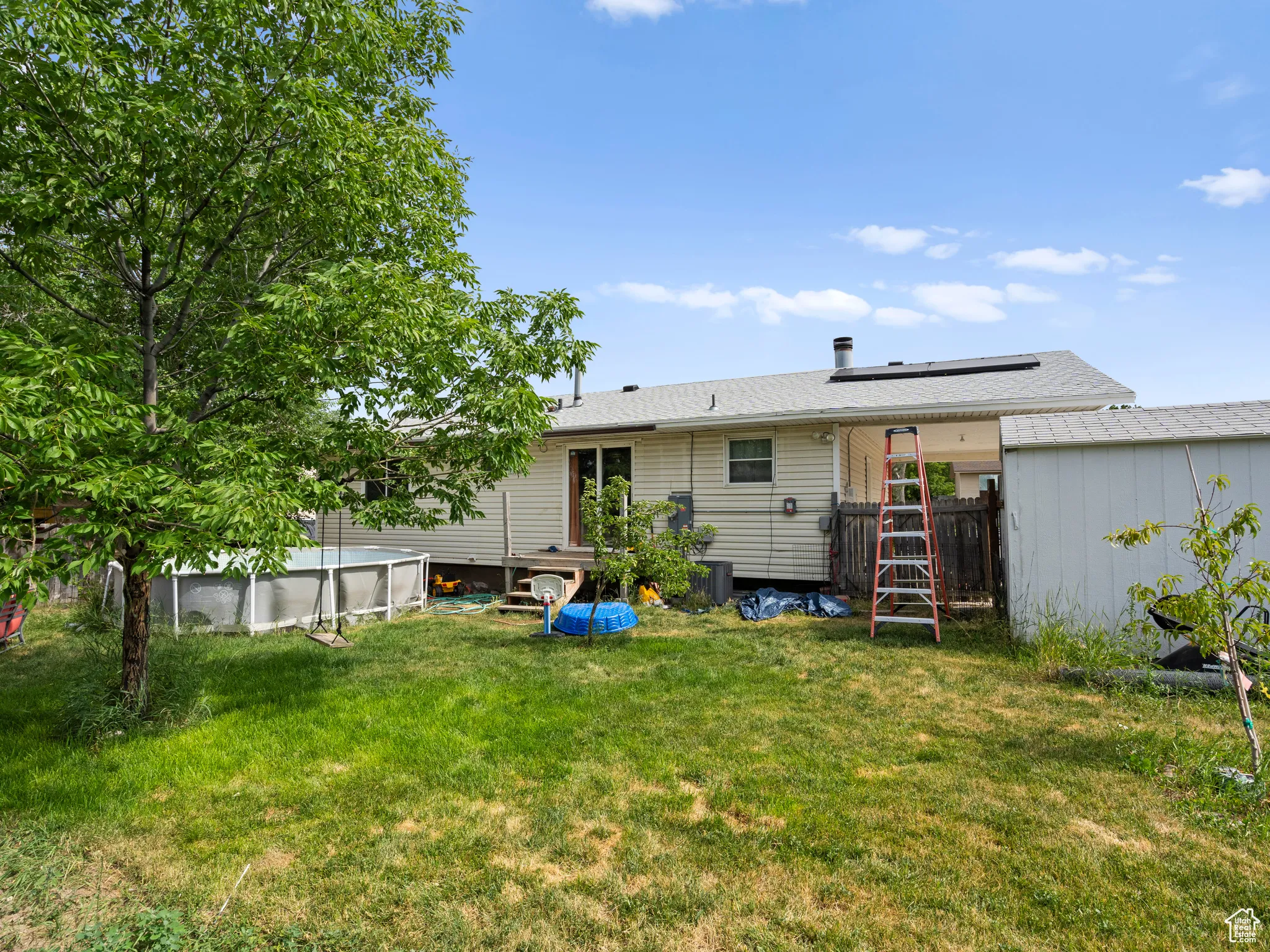 Rear view of property with an outdoor pool and roof mounted solar panels