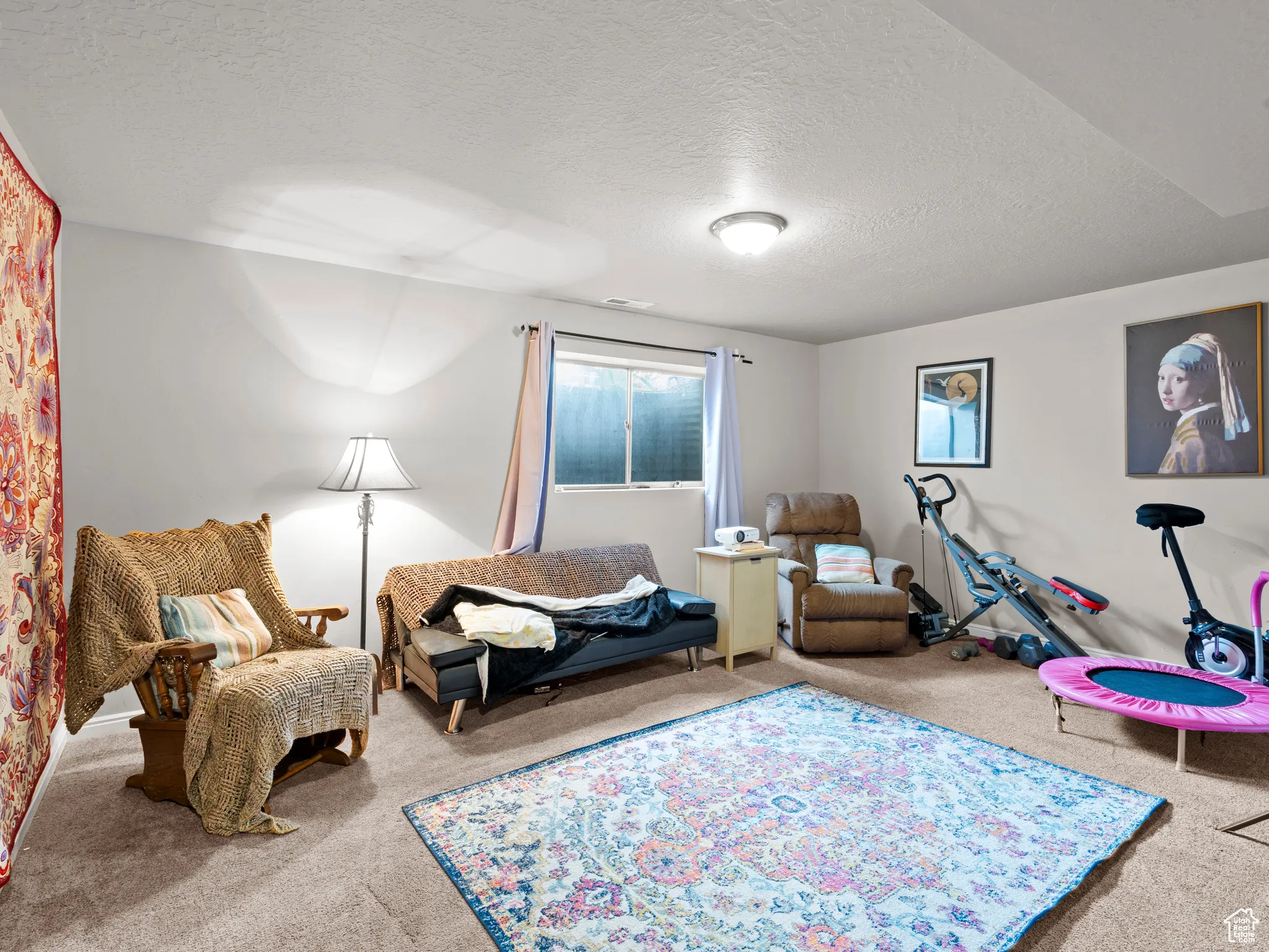 Sitting room featuring carpet and a textured ceiling