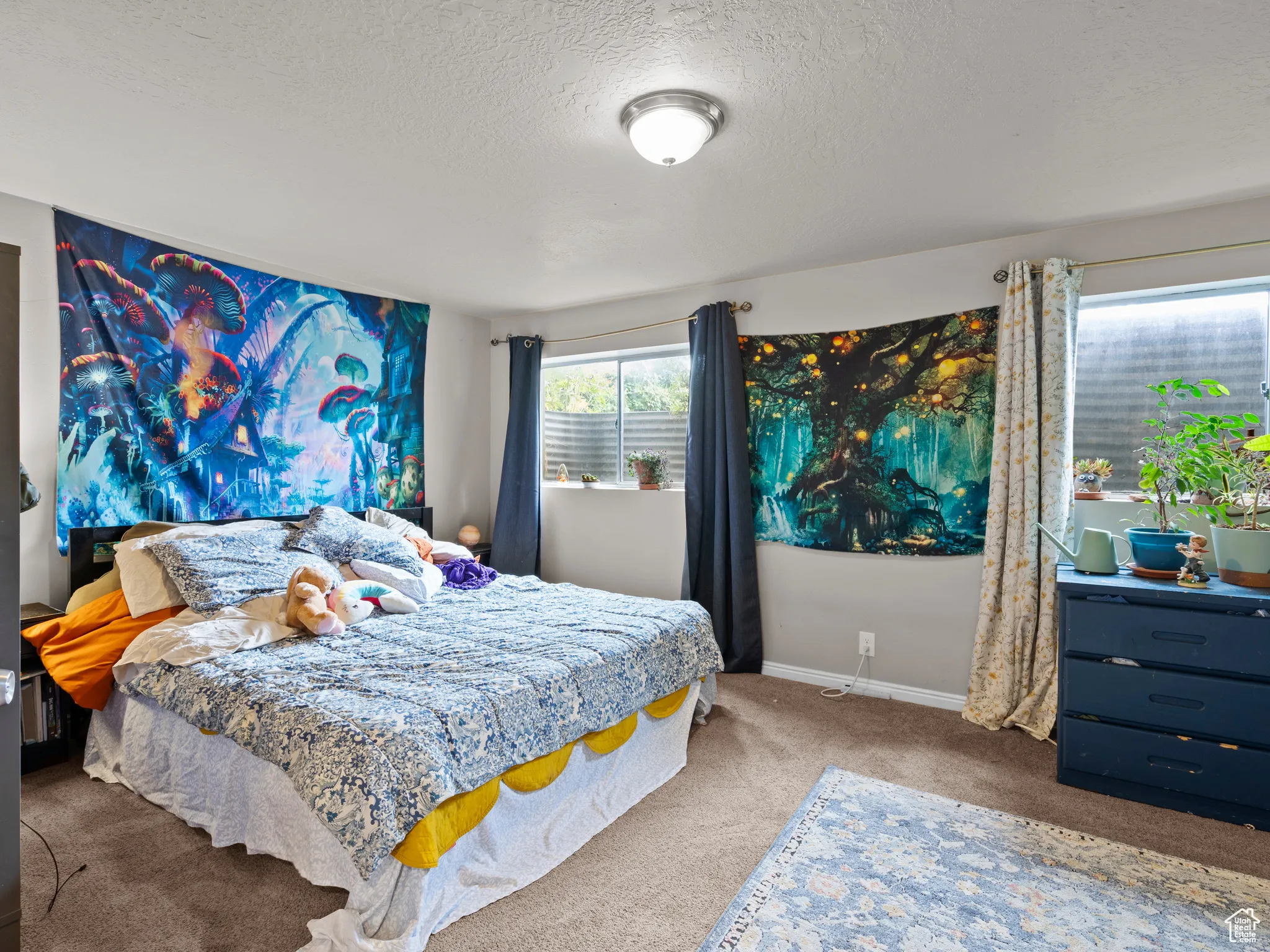 Carpeted bedroom with a textured ceiling and baseboards