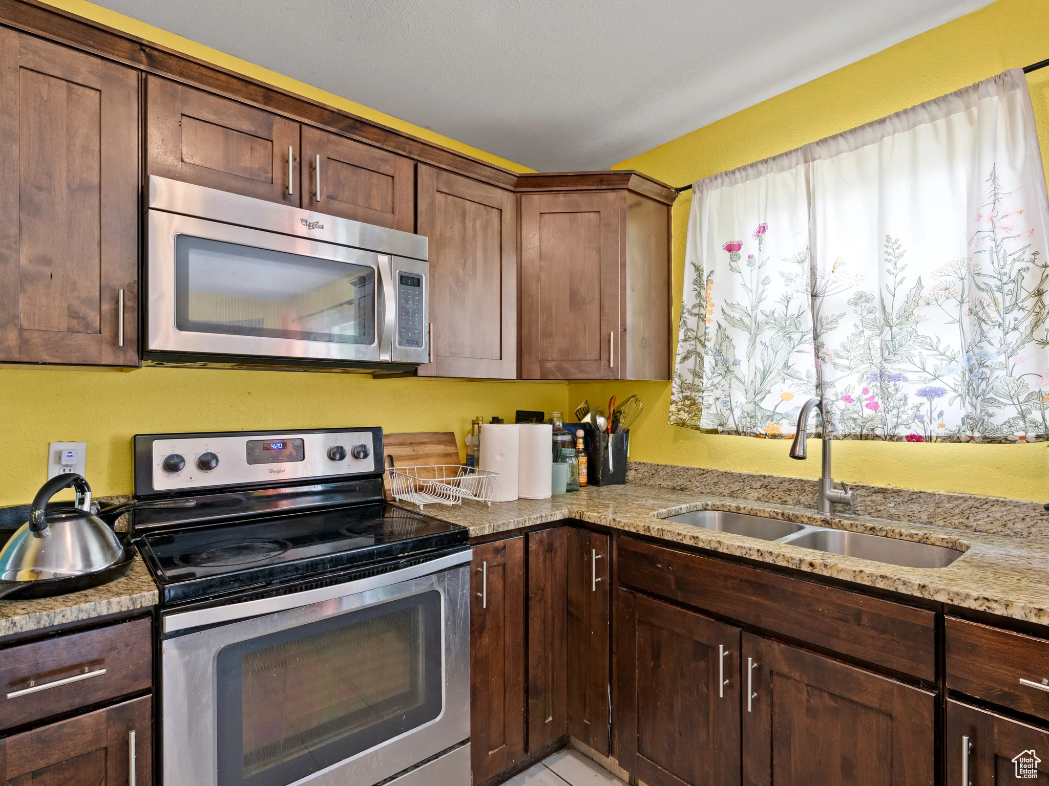 Kitchen featuring stainless steel appliances and light stone countertops
