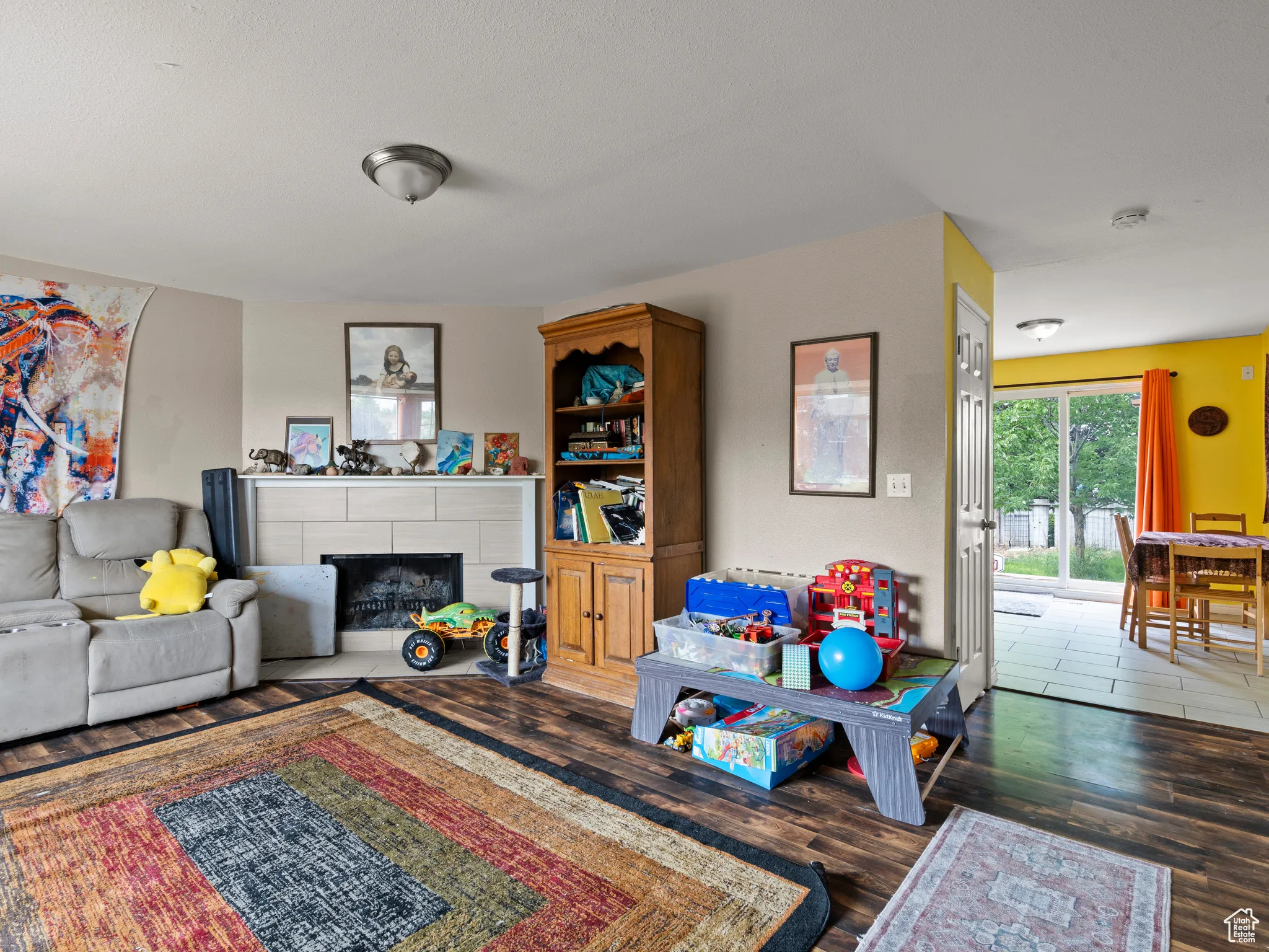 Living area with wood finished floors and a tiled fireplace