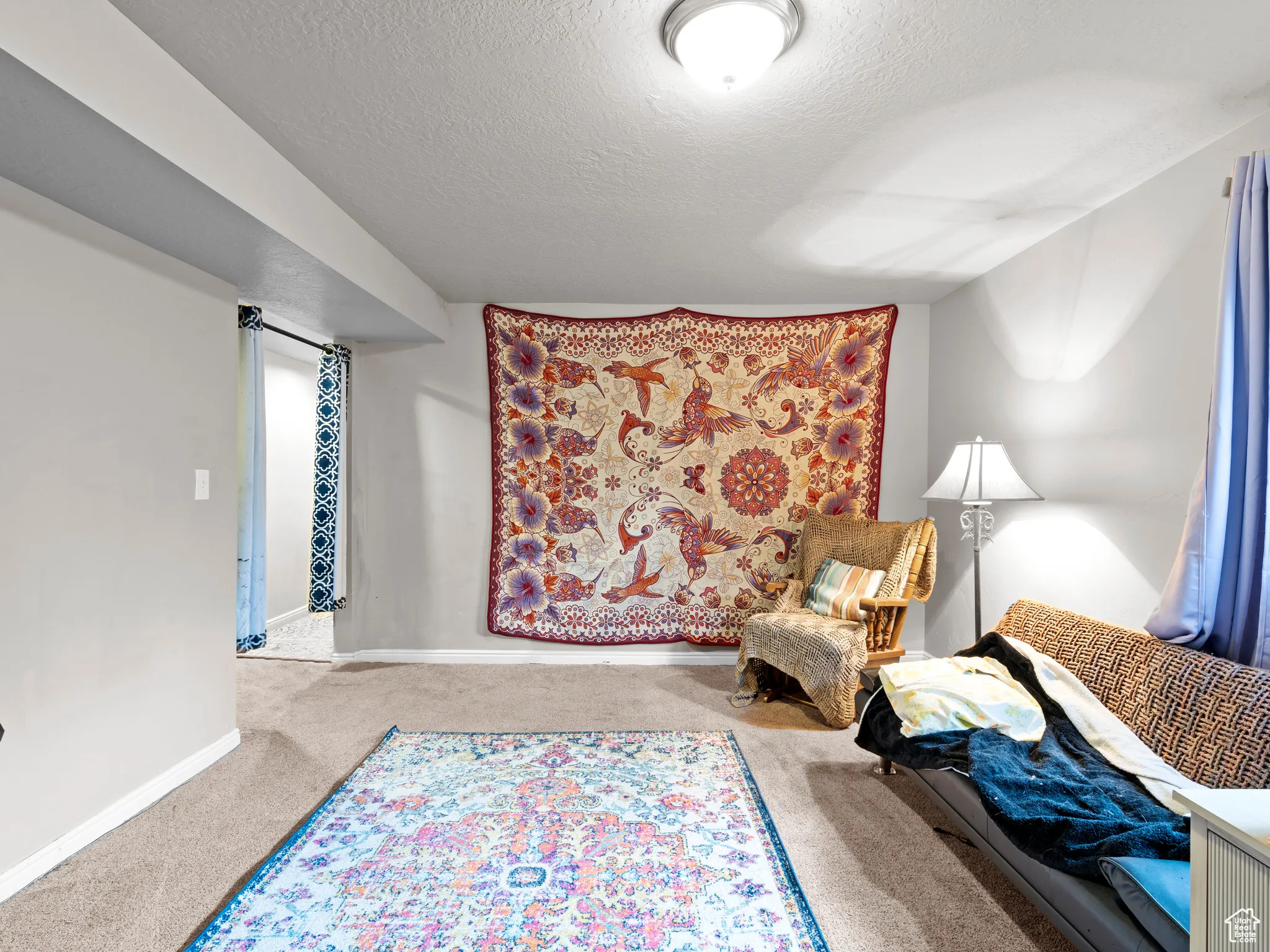 Sitting room featuring carpet flooring and a textured ceiling
