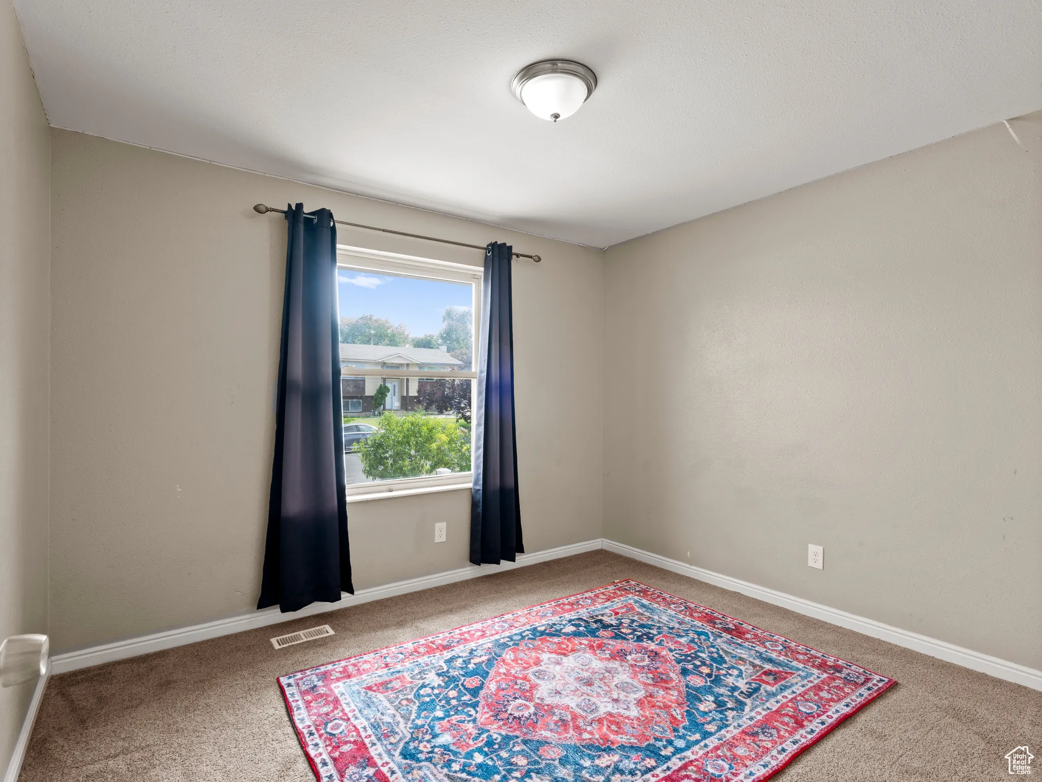 Carpeted spare room with baseboards