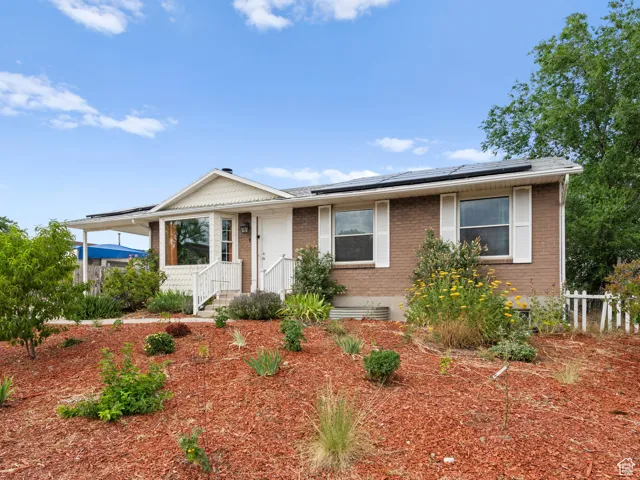 View of front facade with brick siding and roof mounted solar panels