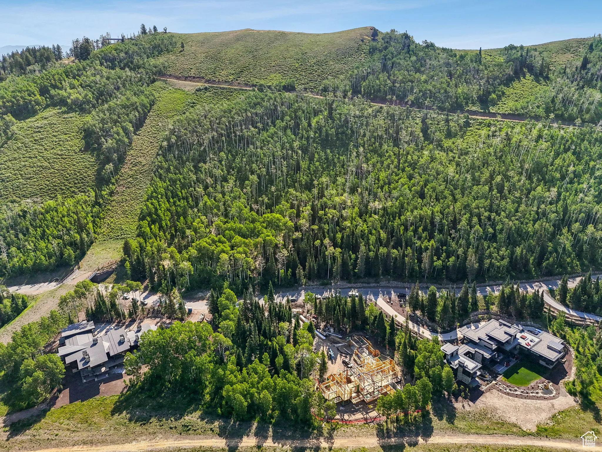 Aerial view of property and surrounding area with a heavily wooded area