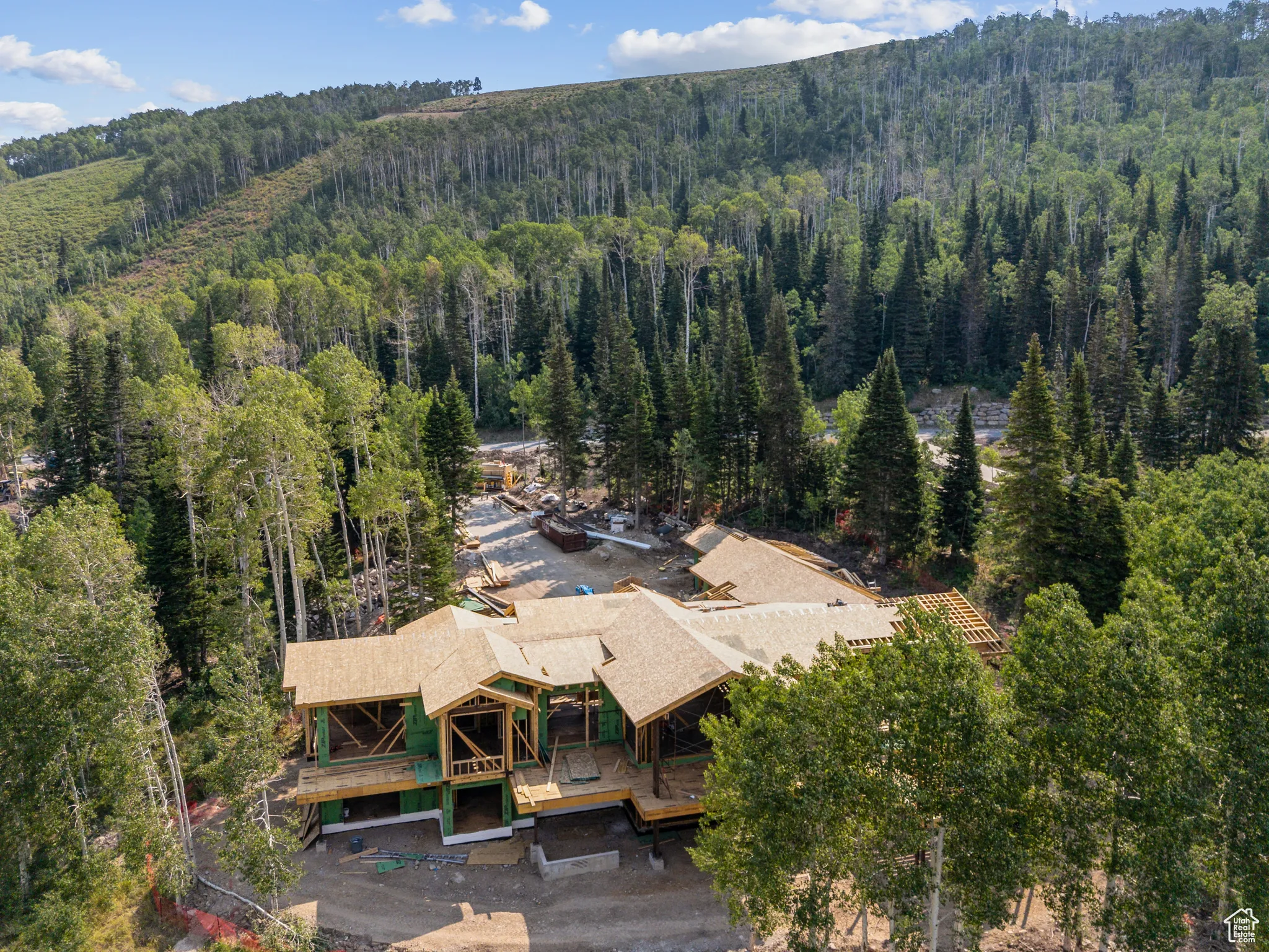 Aerial view of property and surrounding area featuring a forest