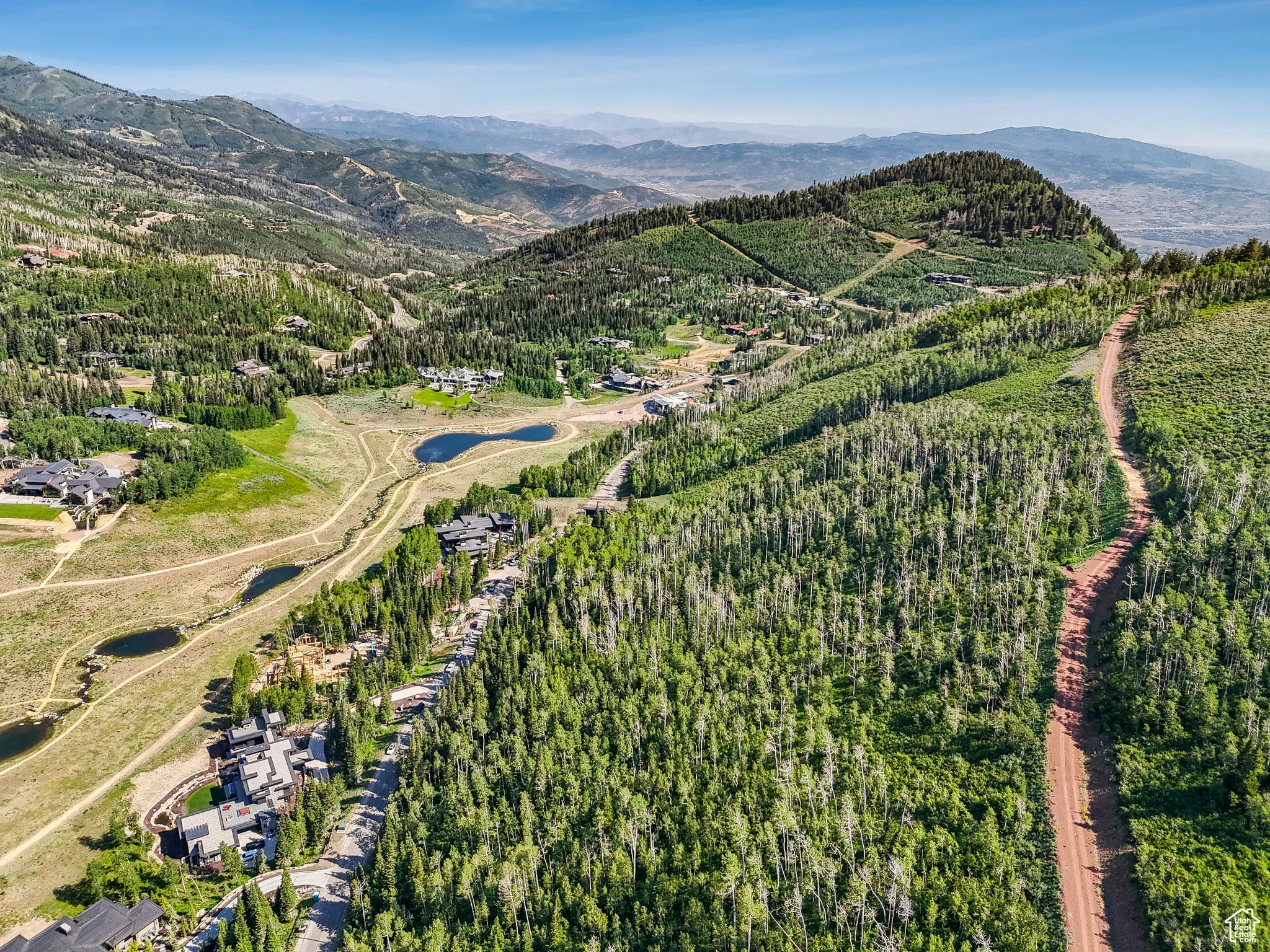 View of property location with a mountainous background and a heavily wooded area