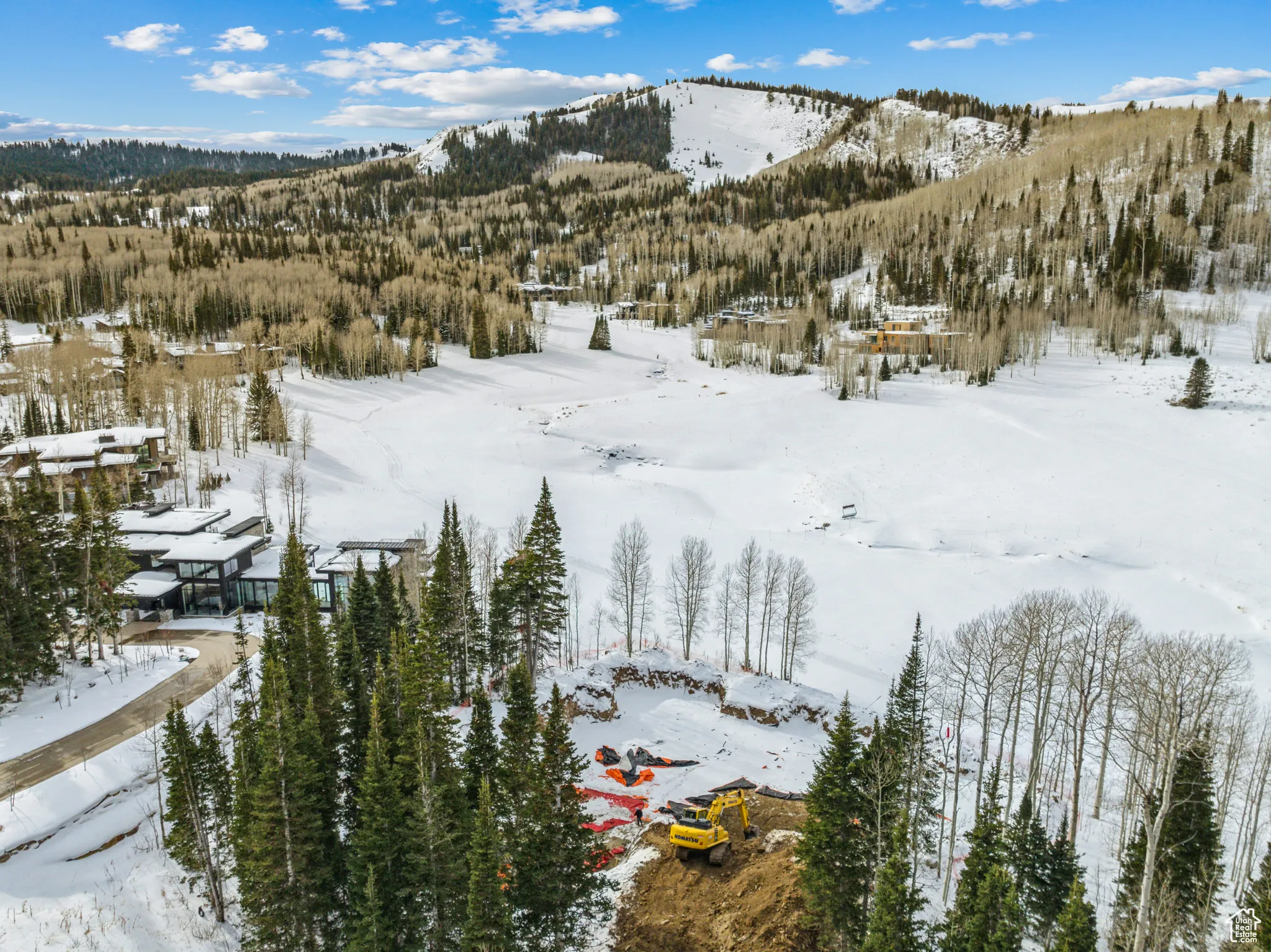 Snowy aerial view featuring a mountain view and a wooded view