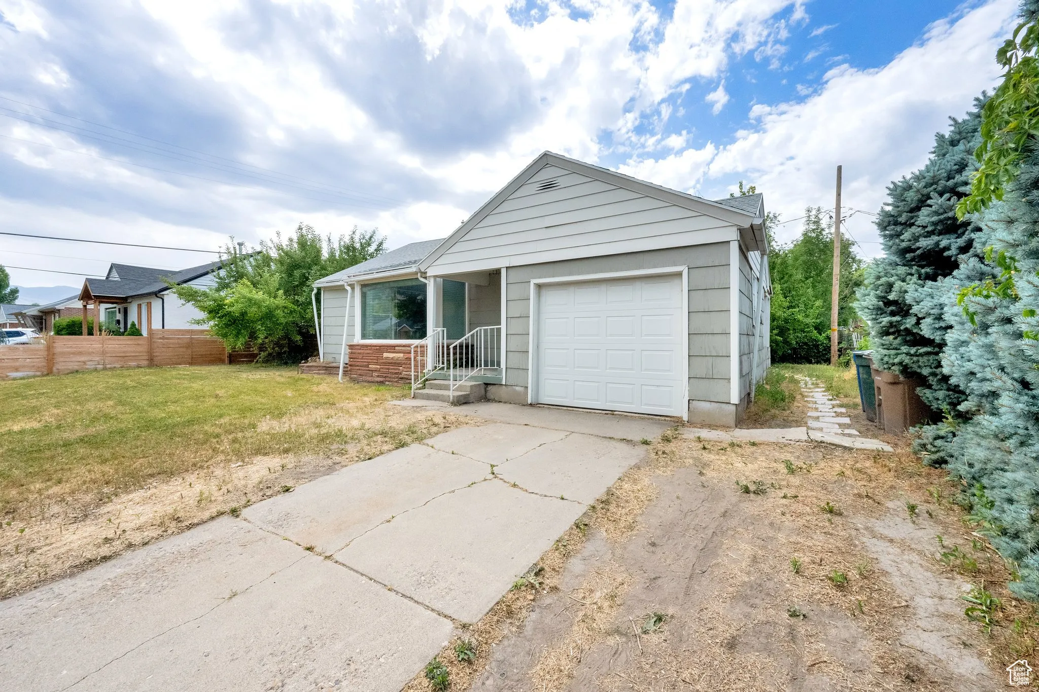 Ranch-style home featuring concrete driveway and a garage