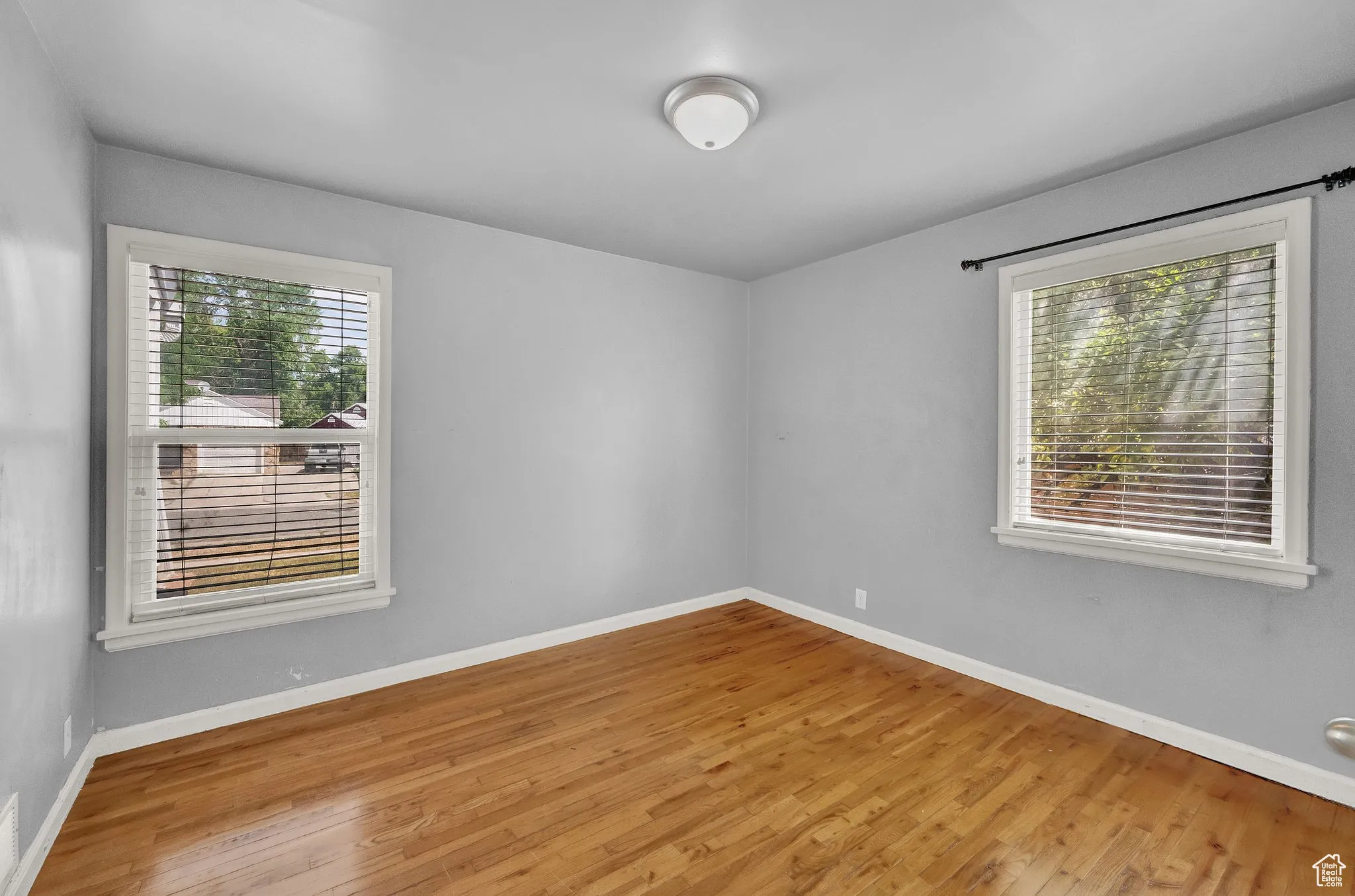 Spare room with plenty of natural light and wood finished floors