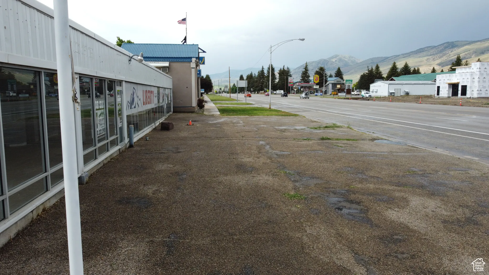View of asphalt road featuring a mountain view, street lights, and traffic signs