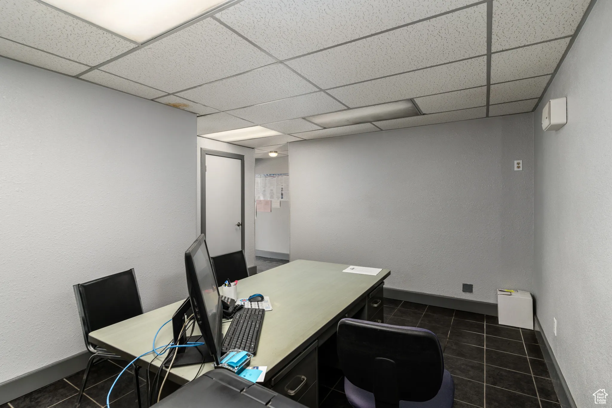 Office space featuring tile patterned floors and a paneled ceiling