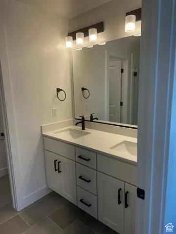 Full bathroom with double vanity and tile patterned flooring
