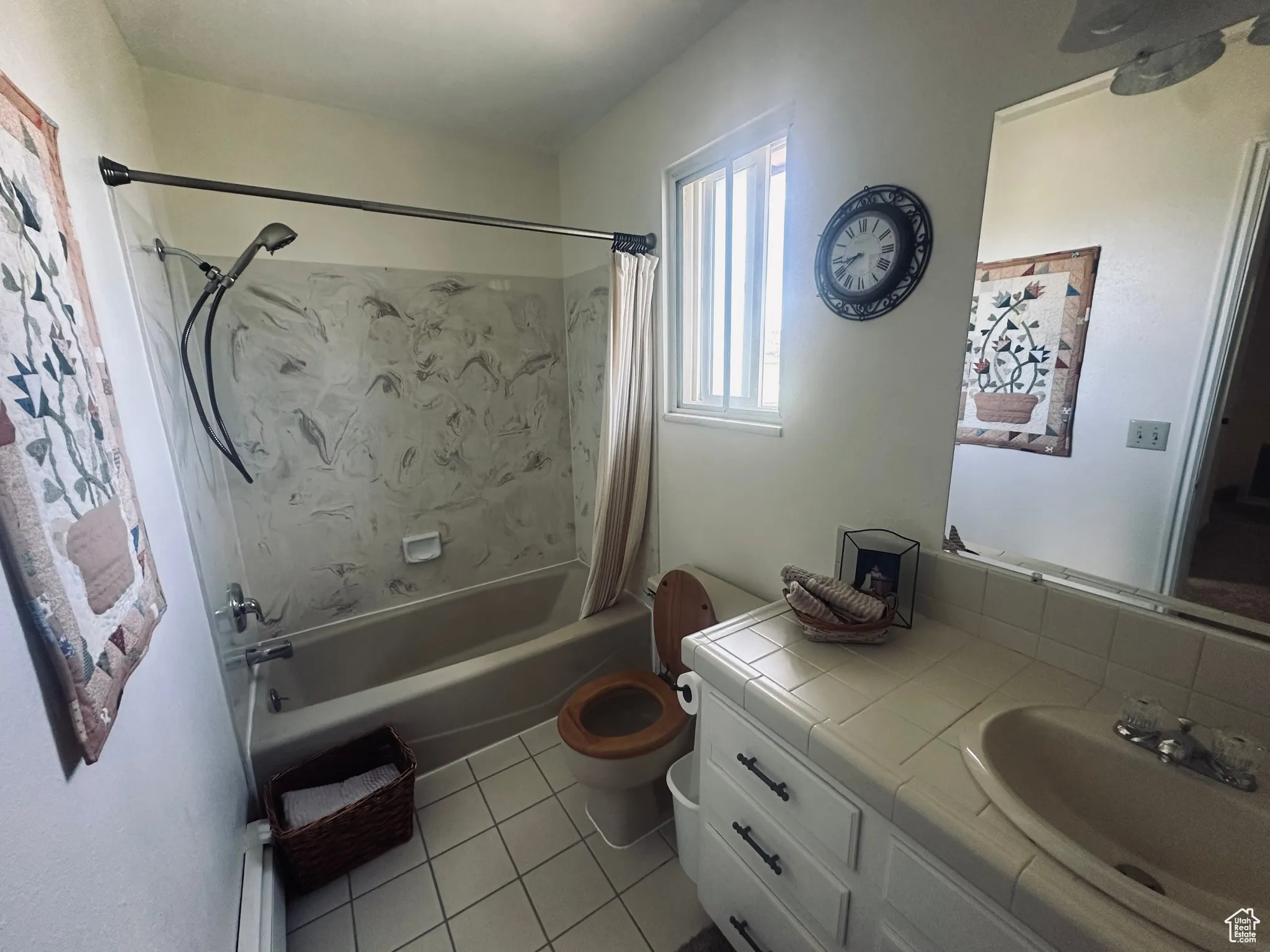 Bathroom with tile patterned flooring, shower / tub combo with curtain, vanity, and baseboard heating