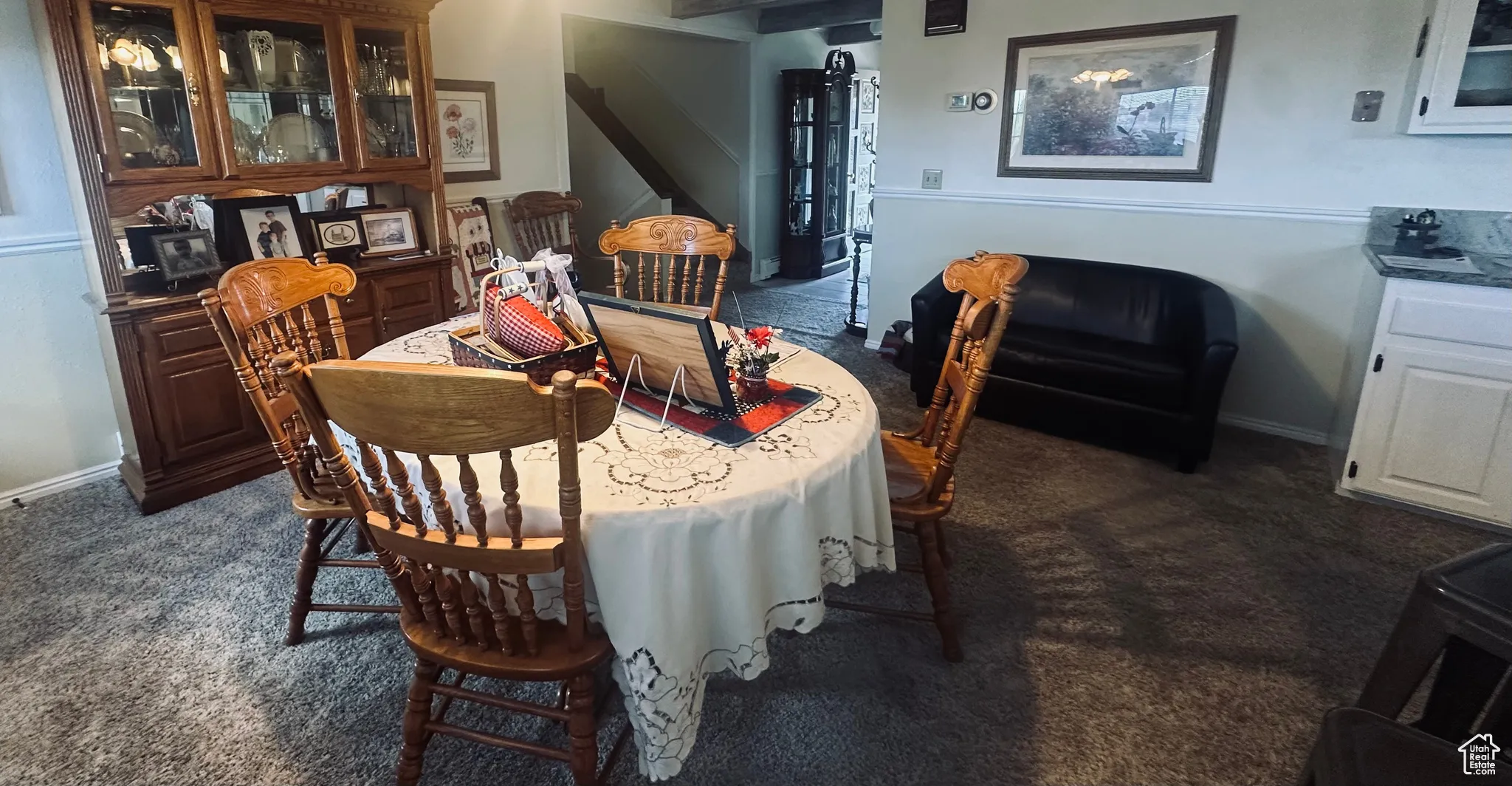 Dining space featuring dark colored carpet and baseboards