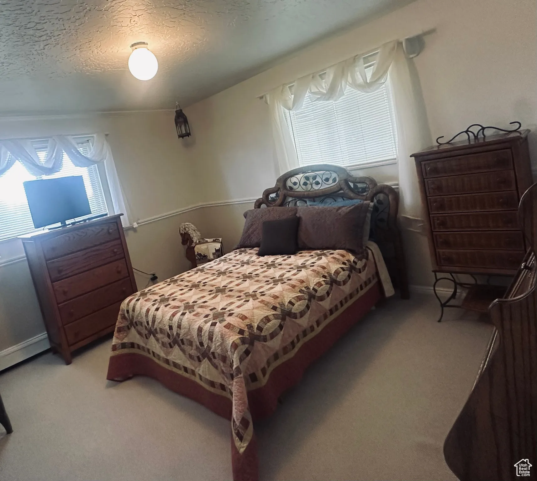 Bedroom featuring light colored carpet and a textured ceiling