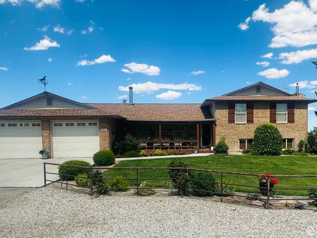 Split level home featuring concrete driveway, brick siding, and a garage