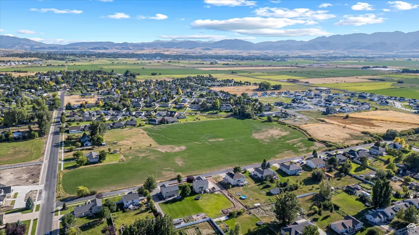 Aerial view of property and surrounding area featuring nearby suburban area